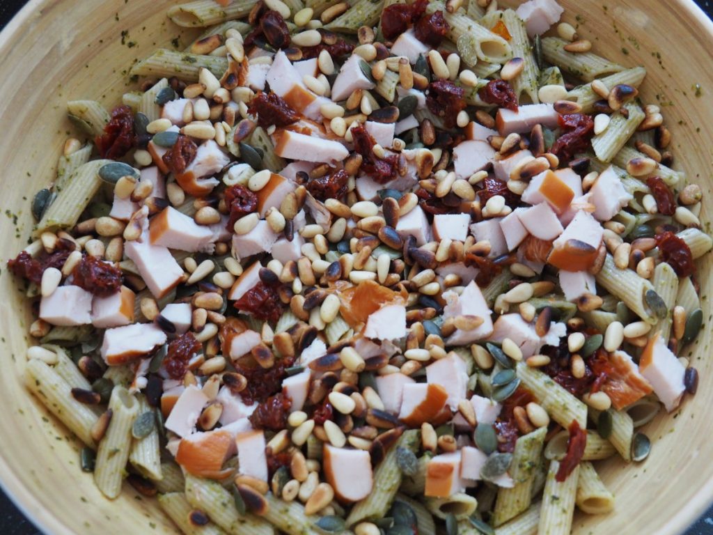 Pastasalade met gerookte kip, pesto en pijnboompitten