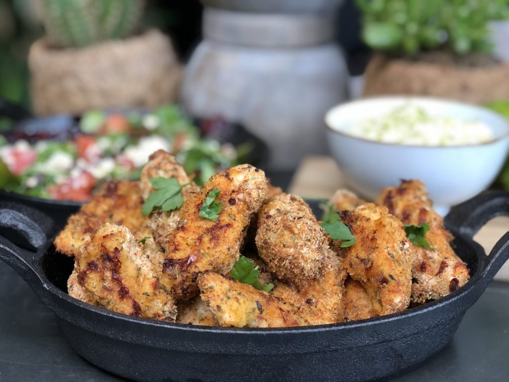 salade met tomaat en fetakaas, geserveerd met gepaneerde Italiaanse kip