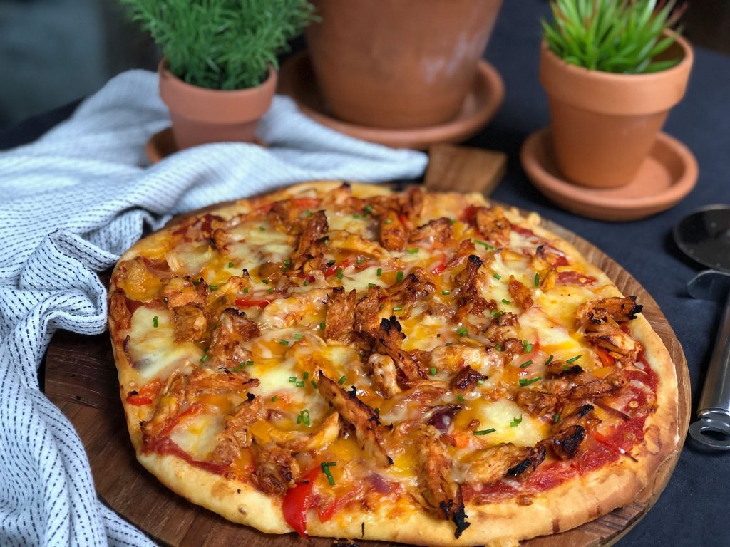 pizza met pikante kip, paprika en rode ui. Lekker met cheddar kaas.