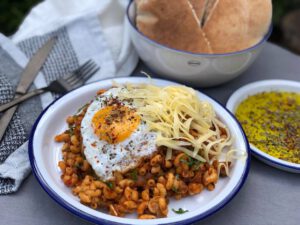 macaroni met gehakt en tomatenpuree geserveerd met kaas en gebakken ei