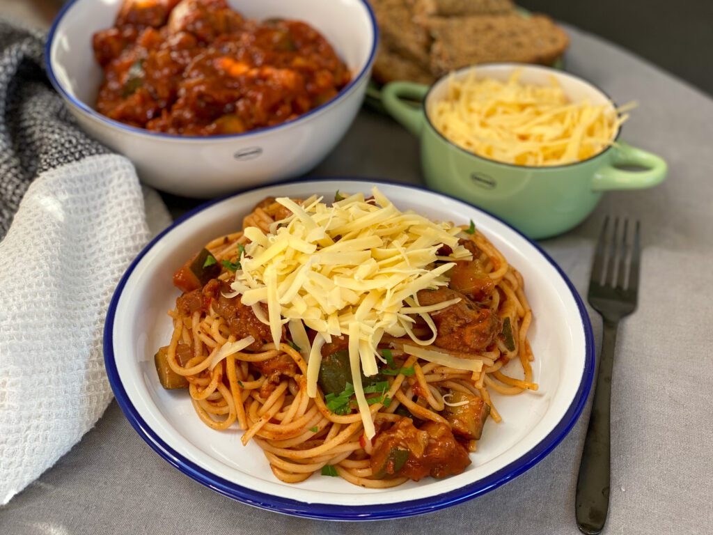 kip stoof in kruidige tomatensaus met pasta en geraspte kaas