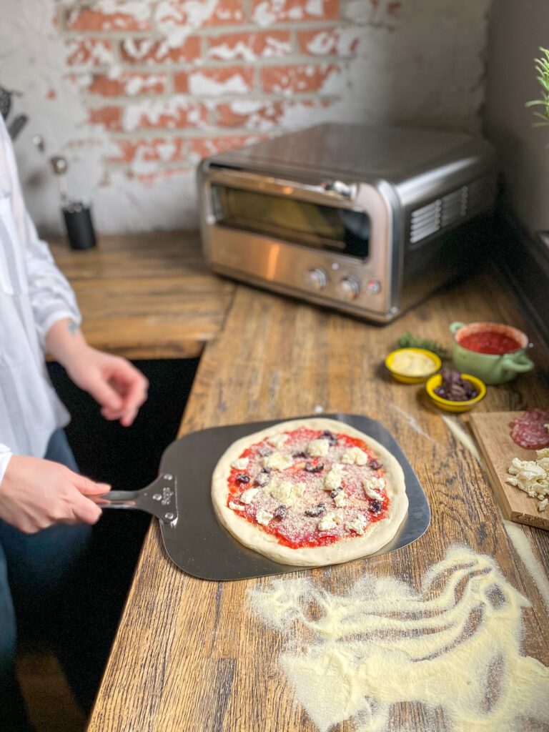 pizza op een pizzaschep scheppen