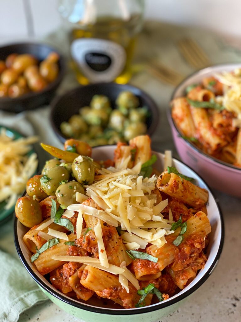 pasta met tonijn in tomatensaus recept - geserveerd met geraspte kaas en olijven als topping