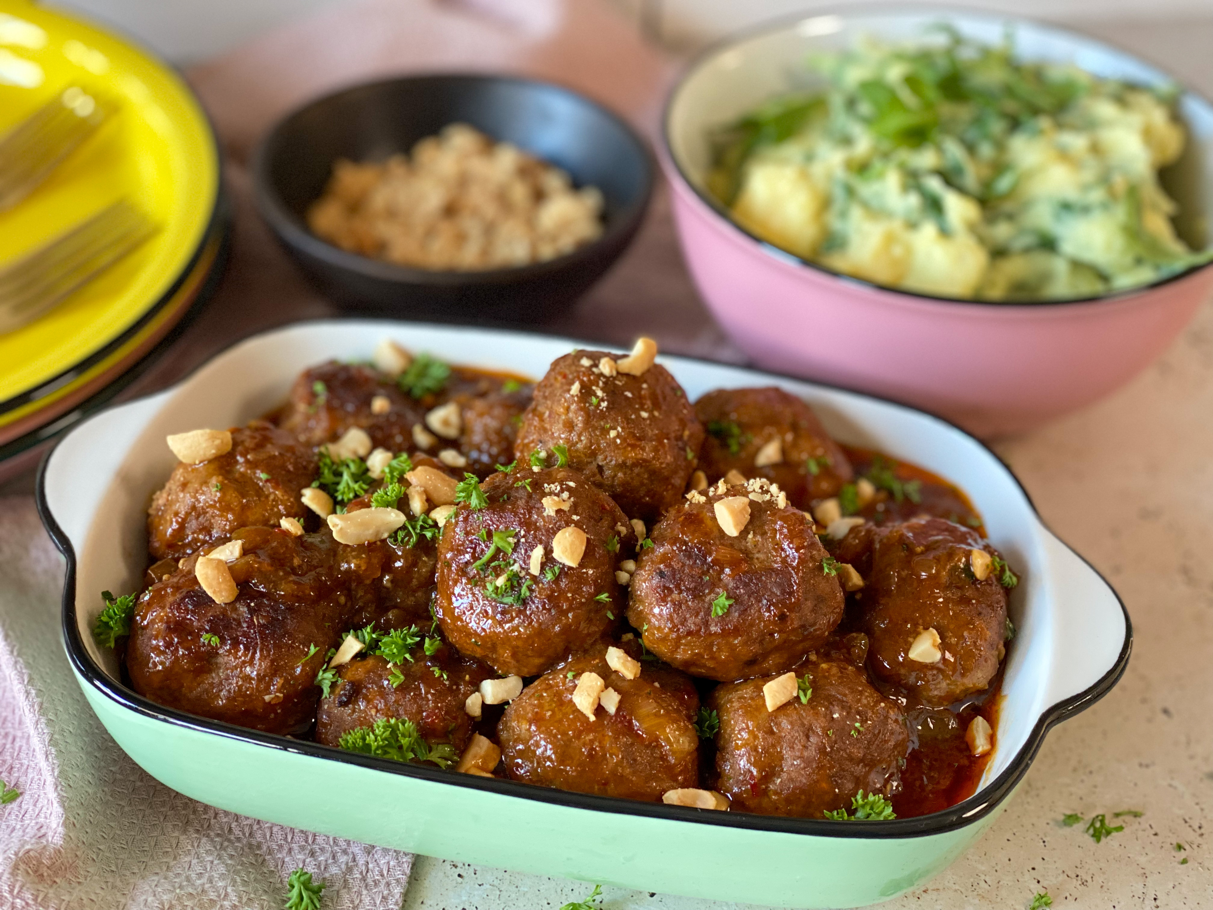pittige en sticky gehaktballetjes met fijngehakte pinda's in groen schaaltje