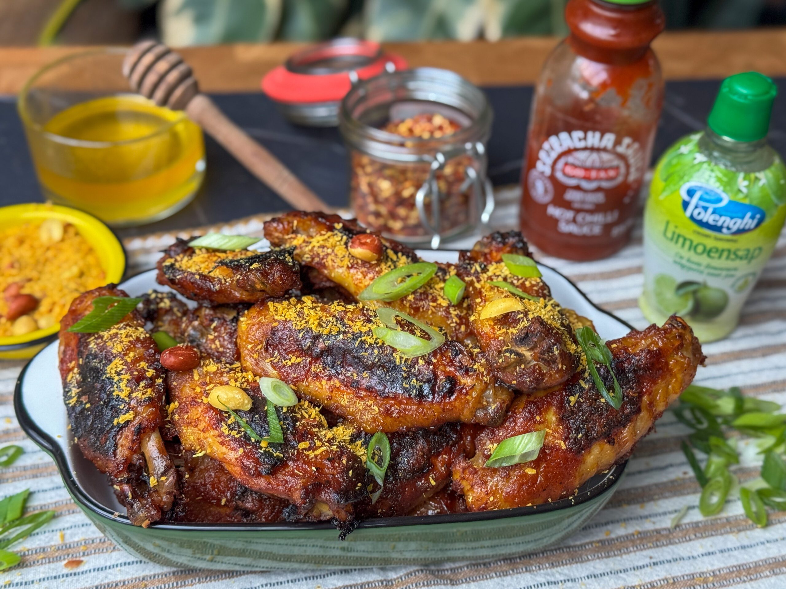 sticky kippenvleugels uit de oven in een saus van sriracha, honing en specerijen.