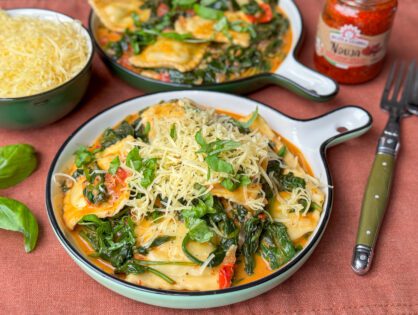 een bord met romige ravioli met verse spinazie en nduja