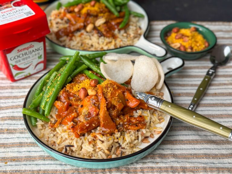 een bordje met sticky paddenstoelen gemaakt in een Gochujang saus met rijst, sperziebonen en kroepoek geserveerd.