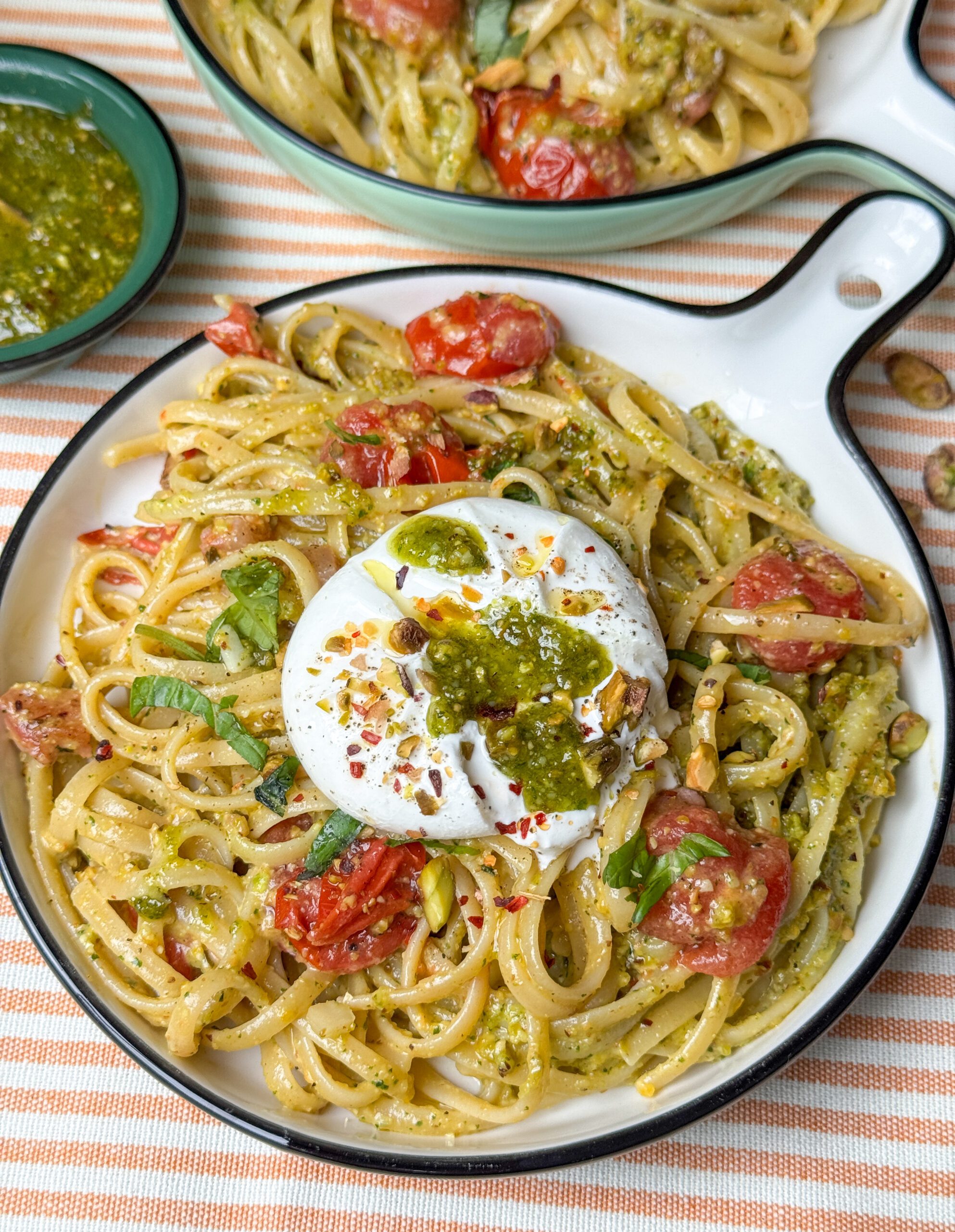 Close-up van pasta met pistache pesto, burrata en geroosterde tomaatjes