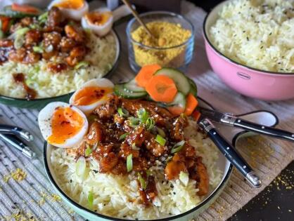 Bord met Thaise kip op kruidige rijst, geserveerd met zachtgekookt ei en ingelegde komkommer – recept uit weekmenu 23 van Familie over de Kook