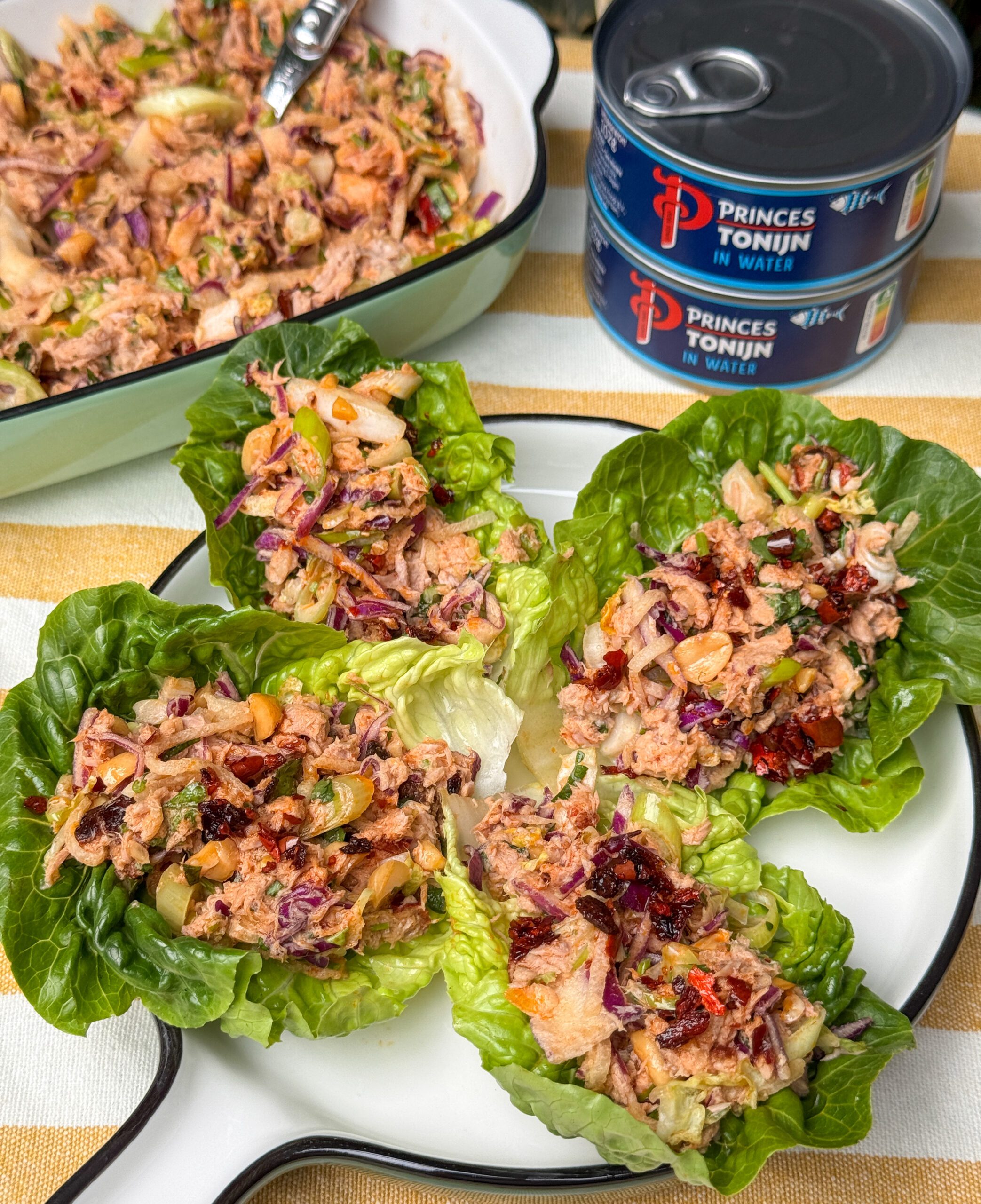 Aziatische tonijnsalade geserveerd in sla blaadjes met crispy chili olie