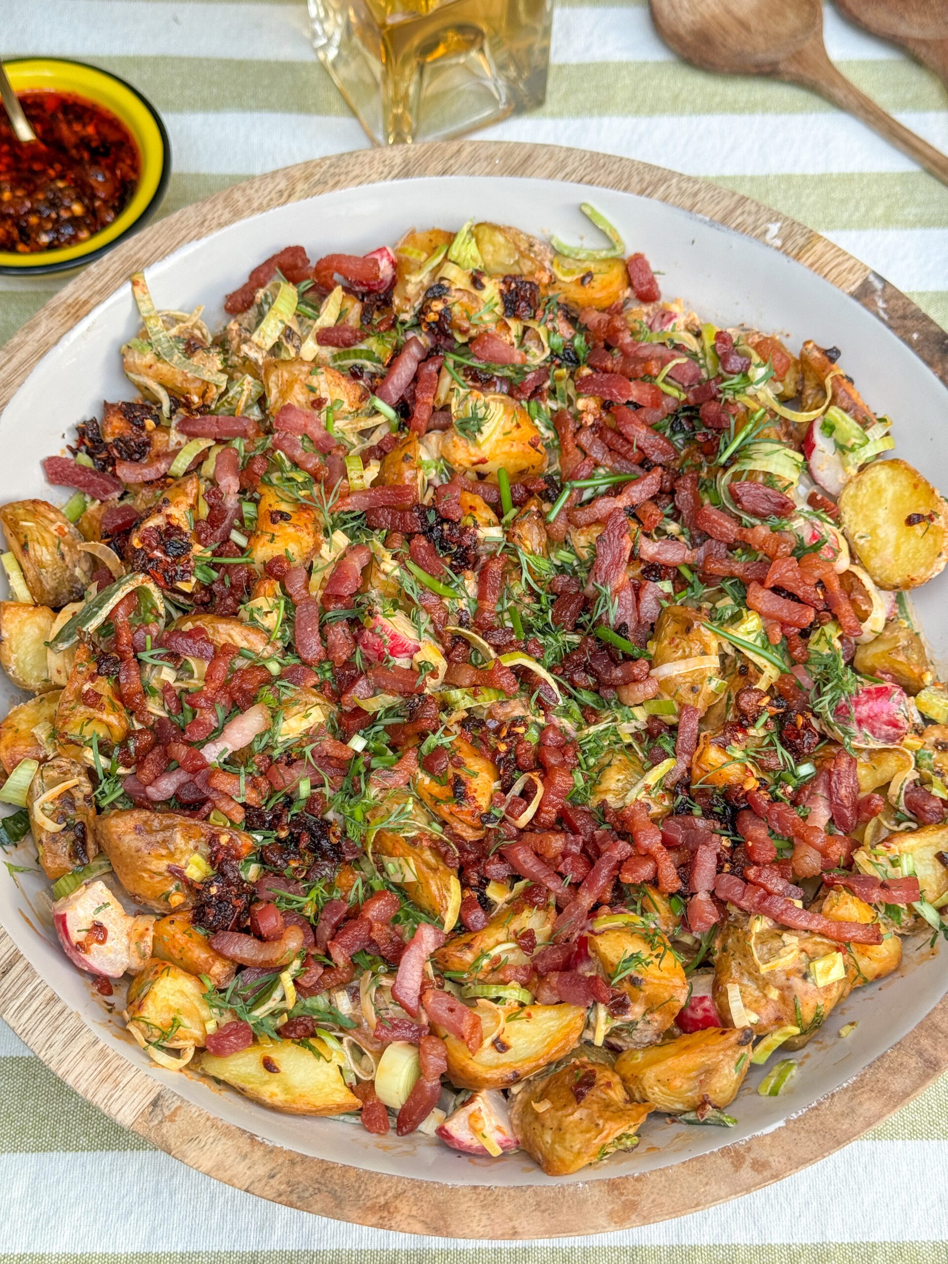 Krokante aardappelsalade met crispy chili olie en Opperdoezer Ronde aardappels, geserveerd als zomers gerecht.