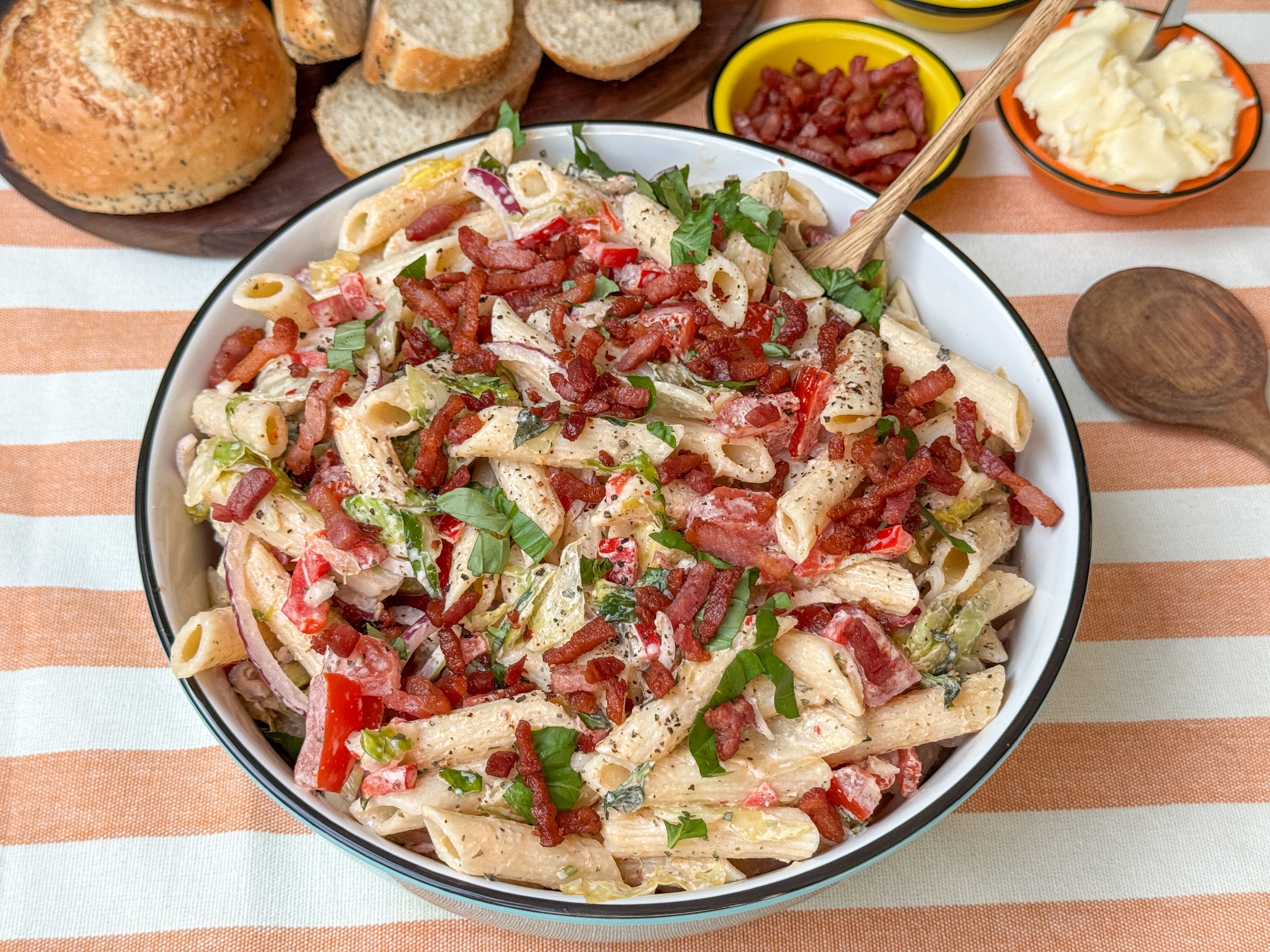 BLT pastasalade - salade met pasta, spek, tomaat en dressing in witte schaal