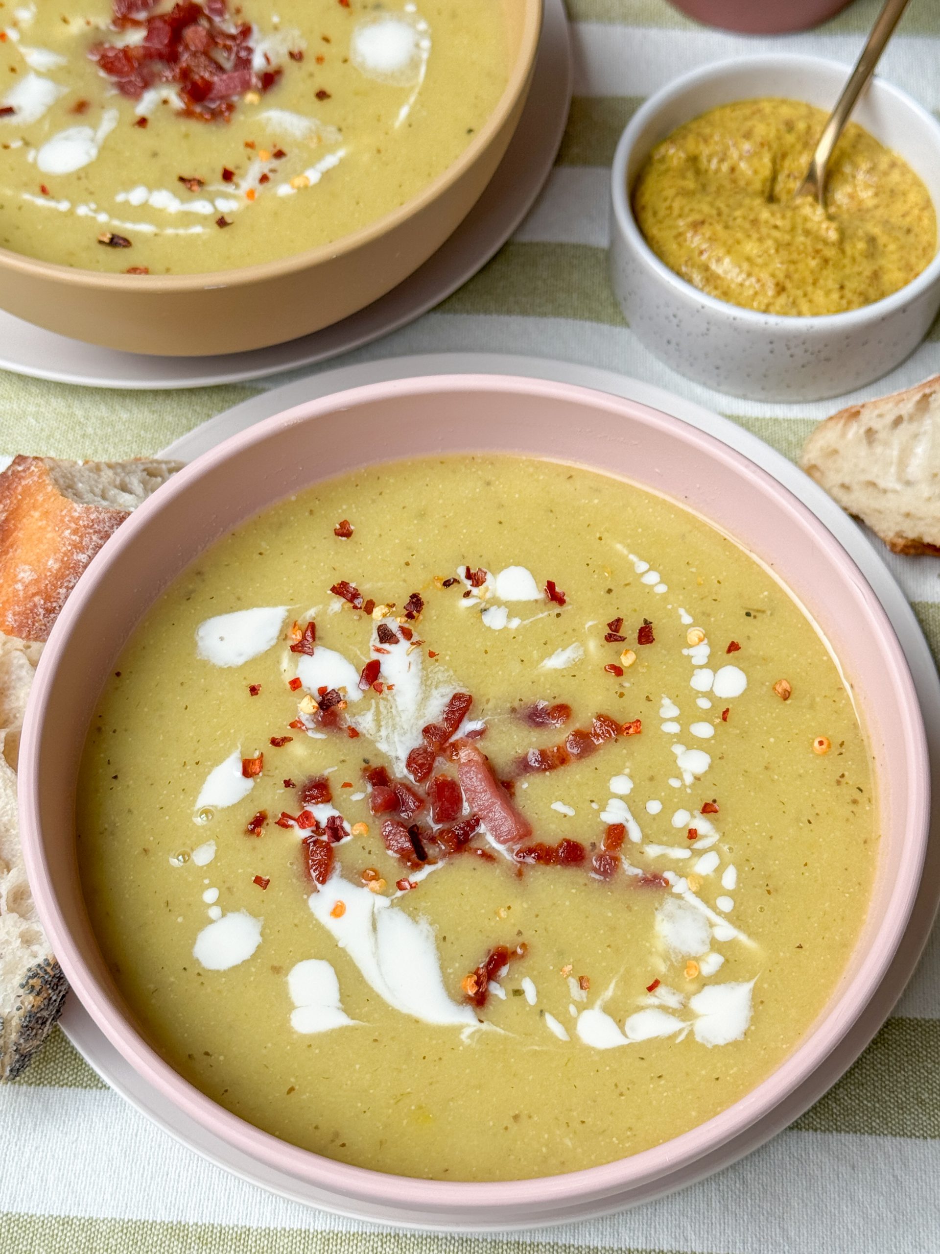 mosterdsoep met spekjes - geserveerd met stokbrood in lichtroze soepkom
