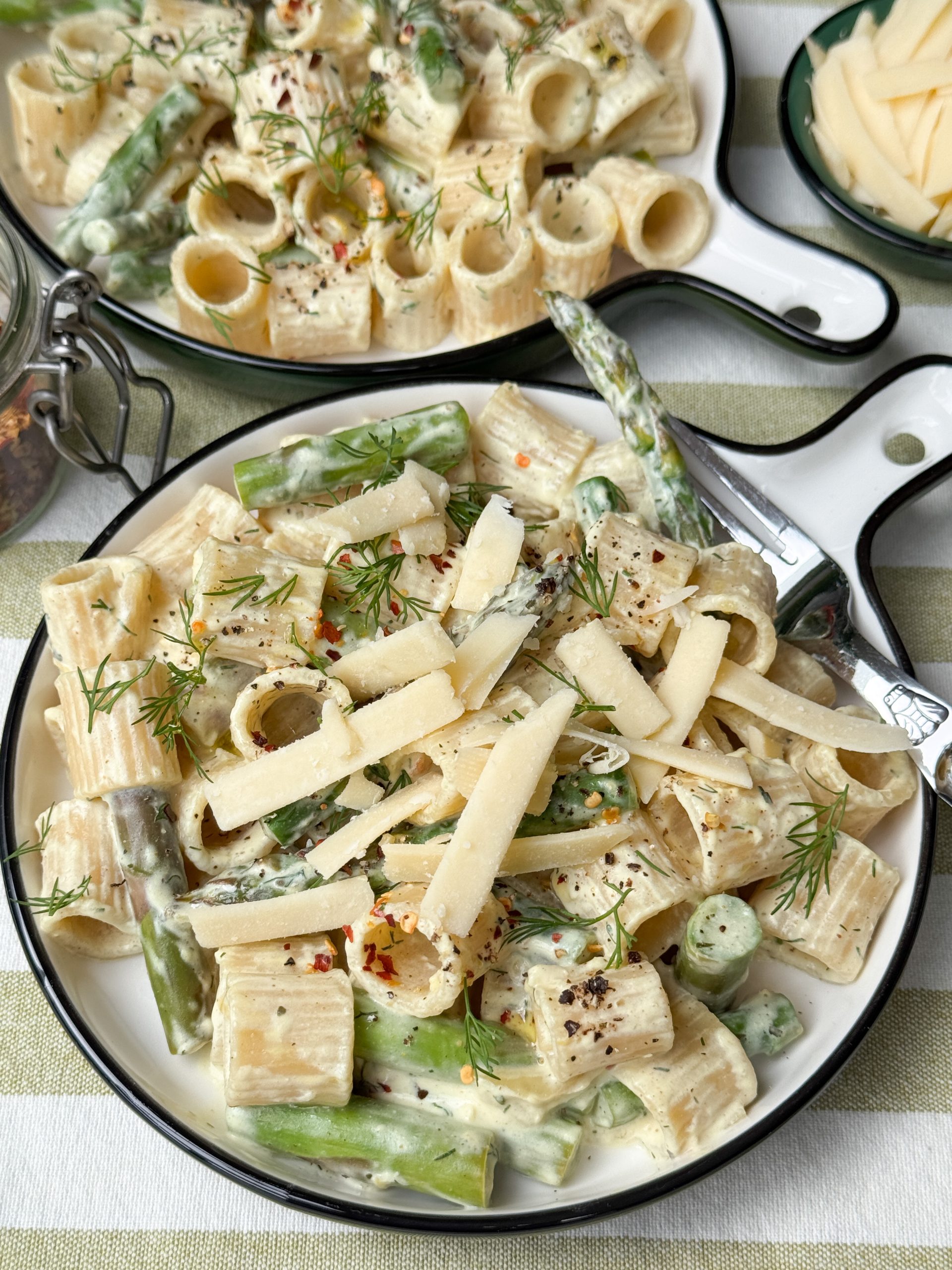 pasta met groene asperges met citroen en dille geserveerd met kaassnippers op rond bord