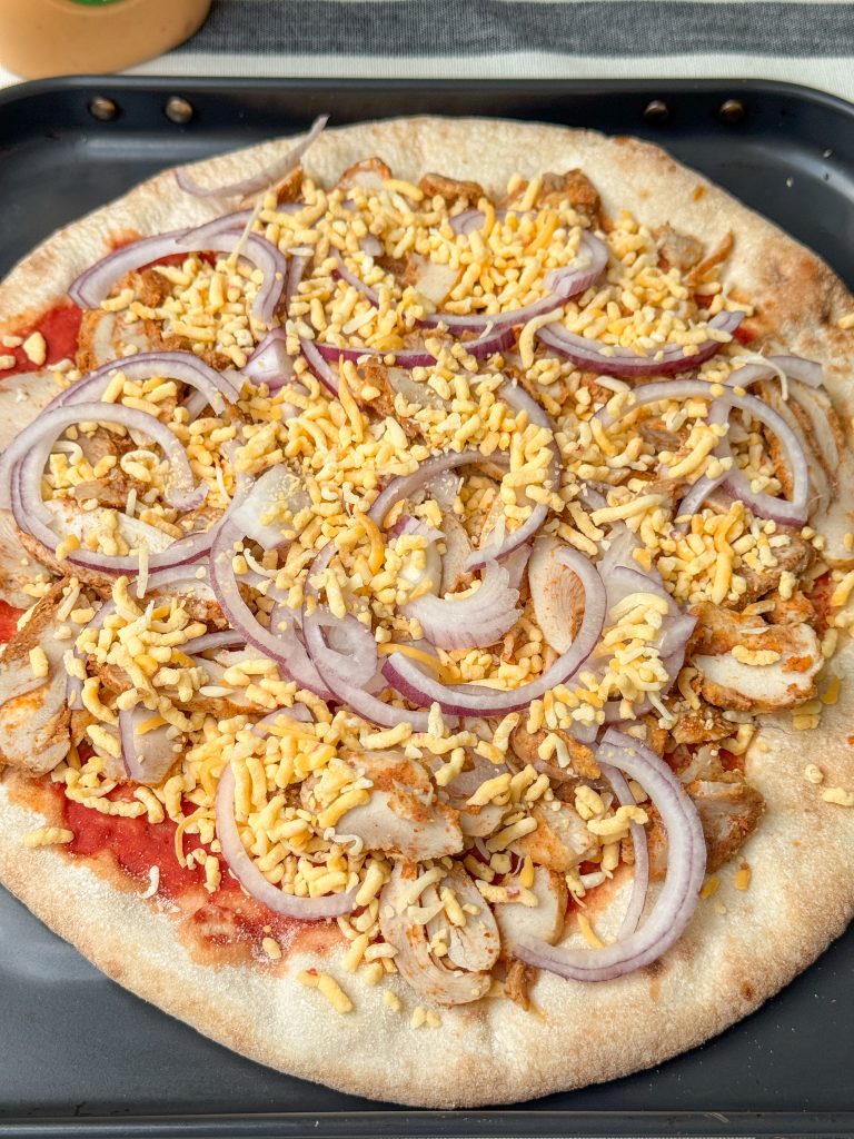 bodem beleggen met kip kebab, rode ui en Tex Mex kaas