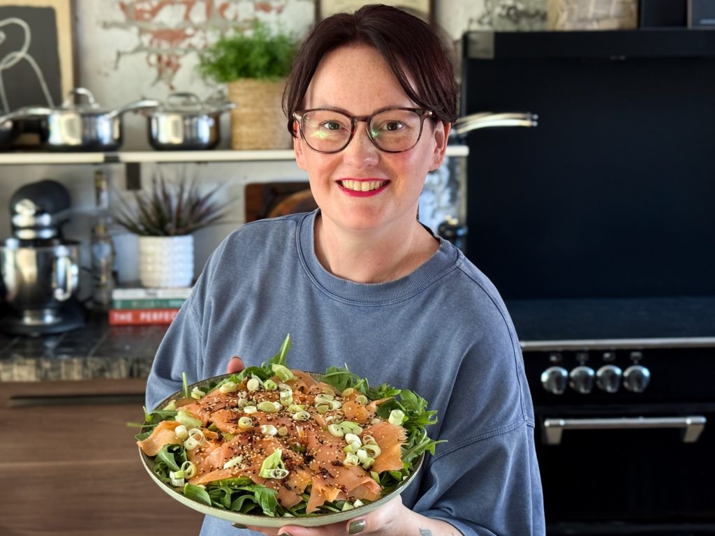 marie-louise houdt bord met zalm carpaccio met pittige aziatische dressing vast