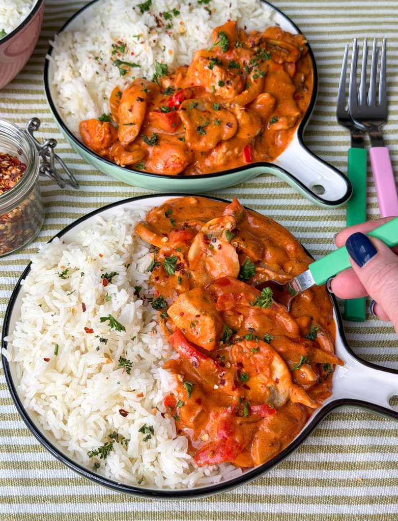Twee borden met romige kip, paprika en champignons op tafel