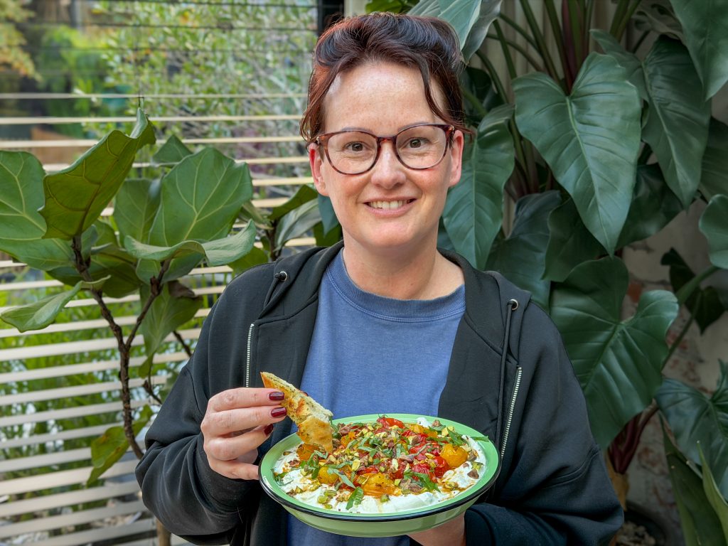 Marie Louise houdt schaal met burrata dip met geroosterde tomaten en stokbrood vast