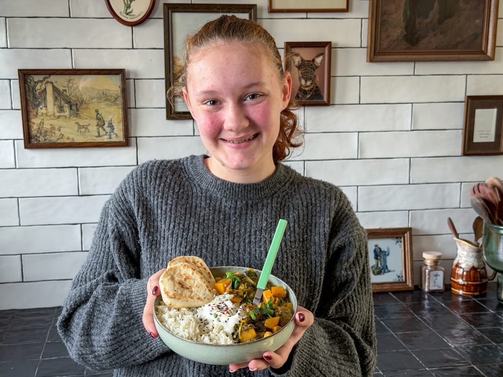 Amaranthe met kom pompoencurry met spinazie en gehaktballetjes geserveerd met rijst en naan