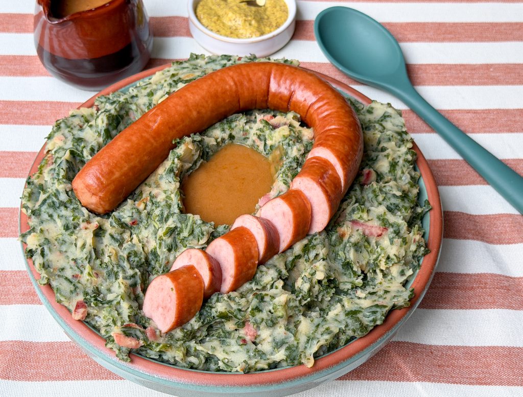 boerenkool stamppot op tafel met rookworst, comfort food met seizoensgroenten van november