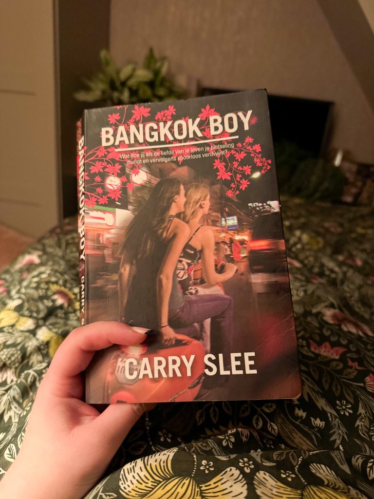 Carry Slee boek “Bangkok Boy” wordt vastgehouden tijdens het lezen in bed.