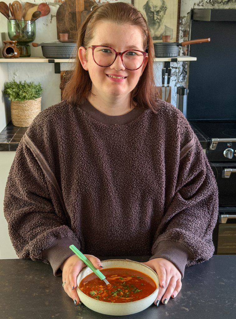 Beaudine met kom Chinese tomatensoep met kip, klaar om te eten