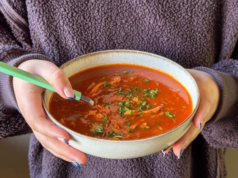 Close up van kom Chinese tomatensoep met kip in handen van Beaudine