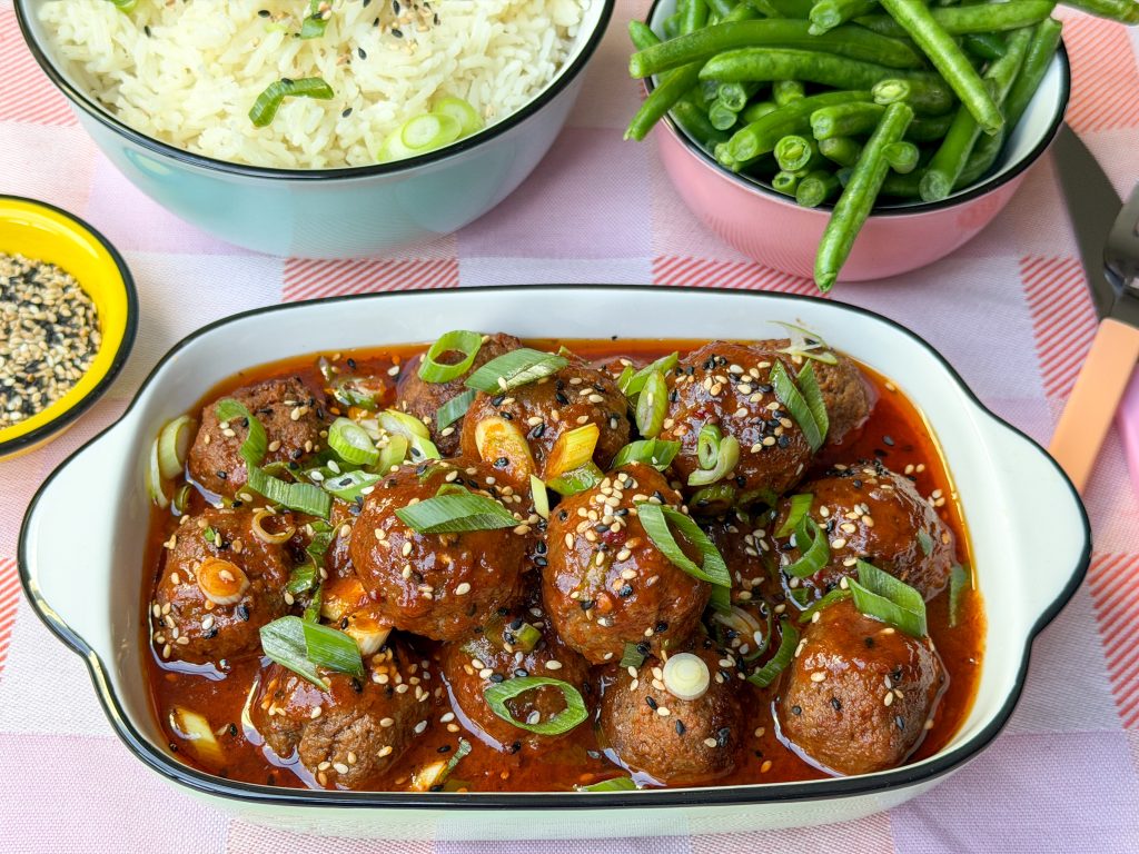 Schaal met gehaktballetjes in zoetzure saus met bosui en sesamzaad