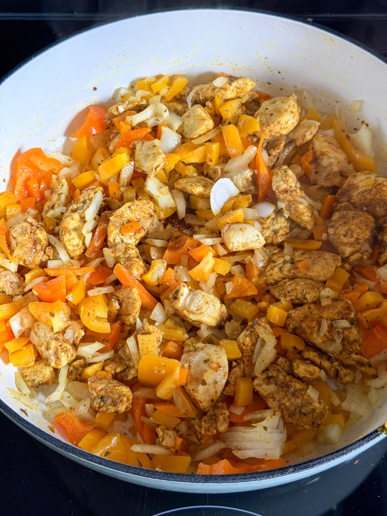 Kip, ui, en blokjes paprika samen aanbakken