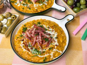 orzo met pompoen, romig eenpansgerecht met spekjes en kruiden op bord