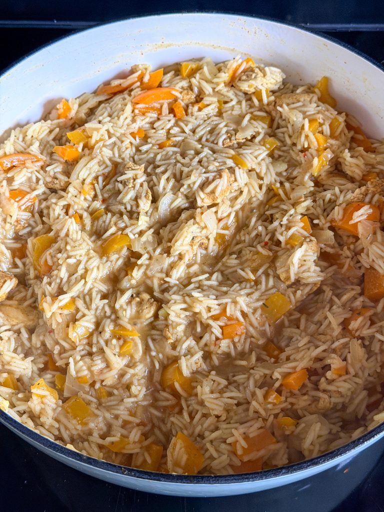 Rijst pruttelt met kip en paprika in het eenpansgerecht