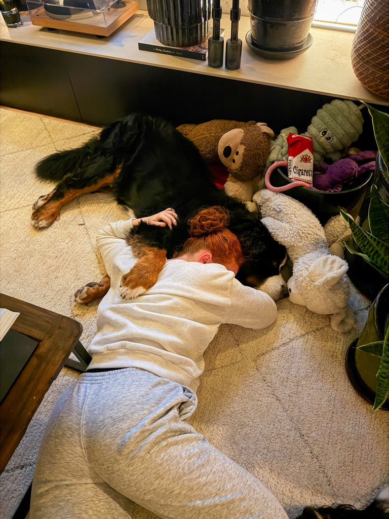 Amaranthe ligt op de vloer met hond Boyd