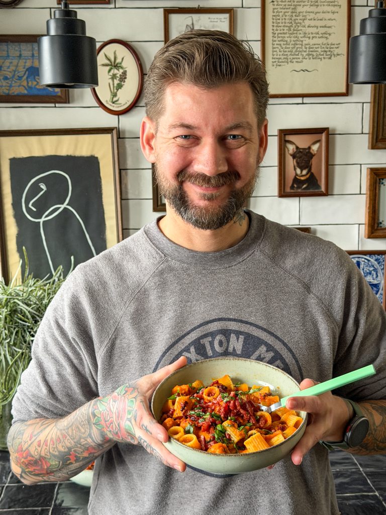 Jan Willem houdt een kom pasta met pompoensaus vast