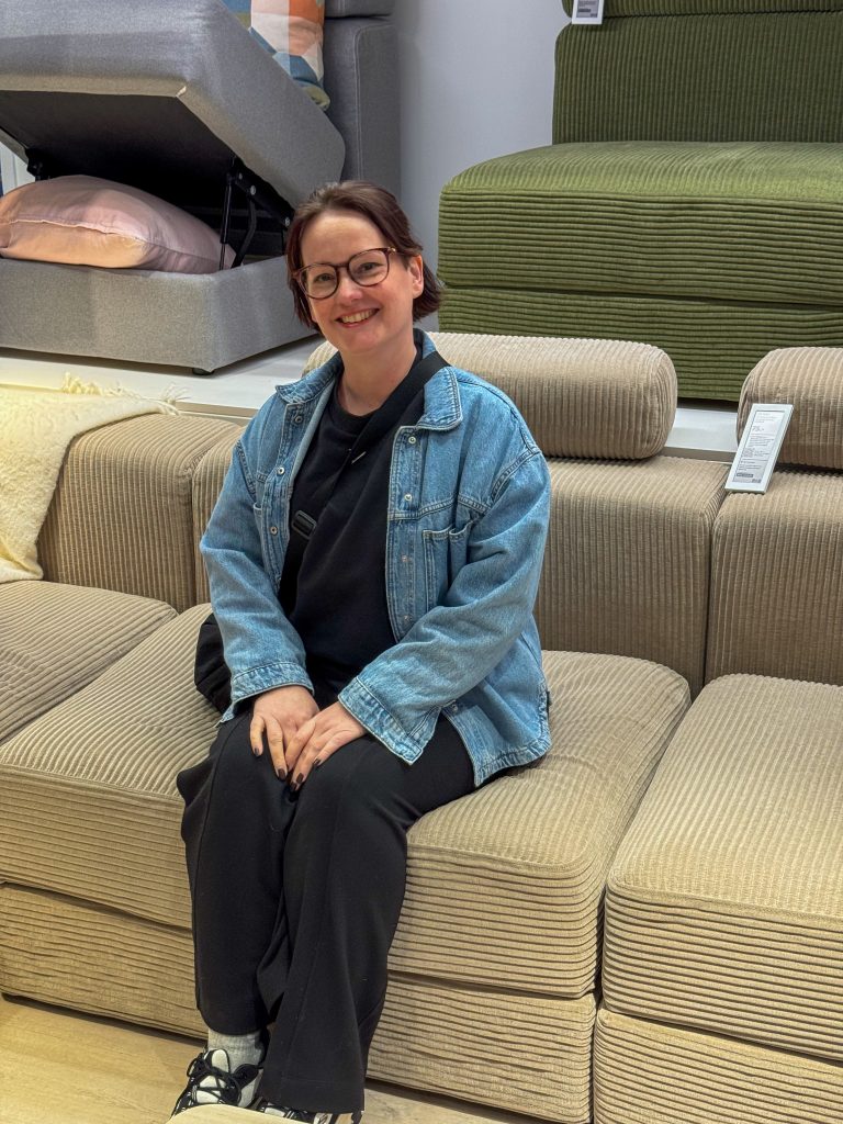 Marie Louise zit op een bank in de meubelwinkel
