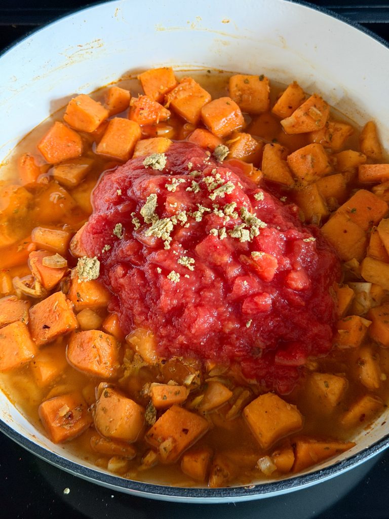 tomatenblokjes en boullion bij de pompoen in de pan