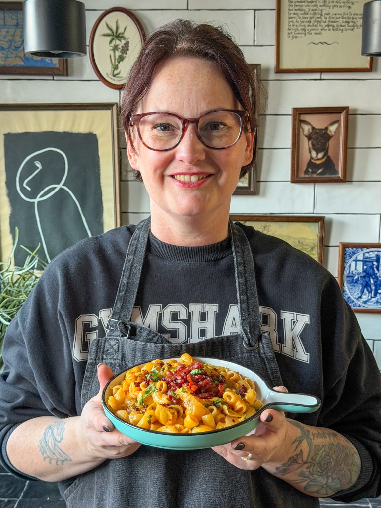 Marie Louise houdt bord met romige witlof pasta vast