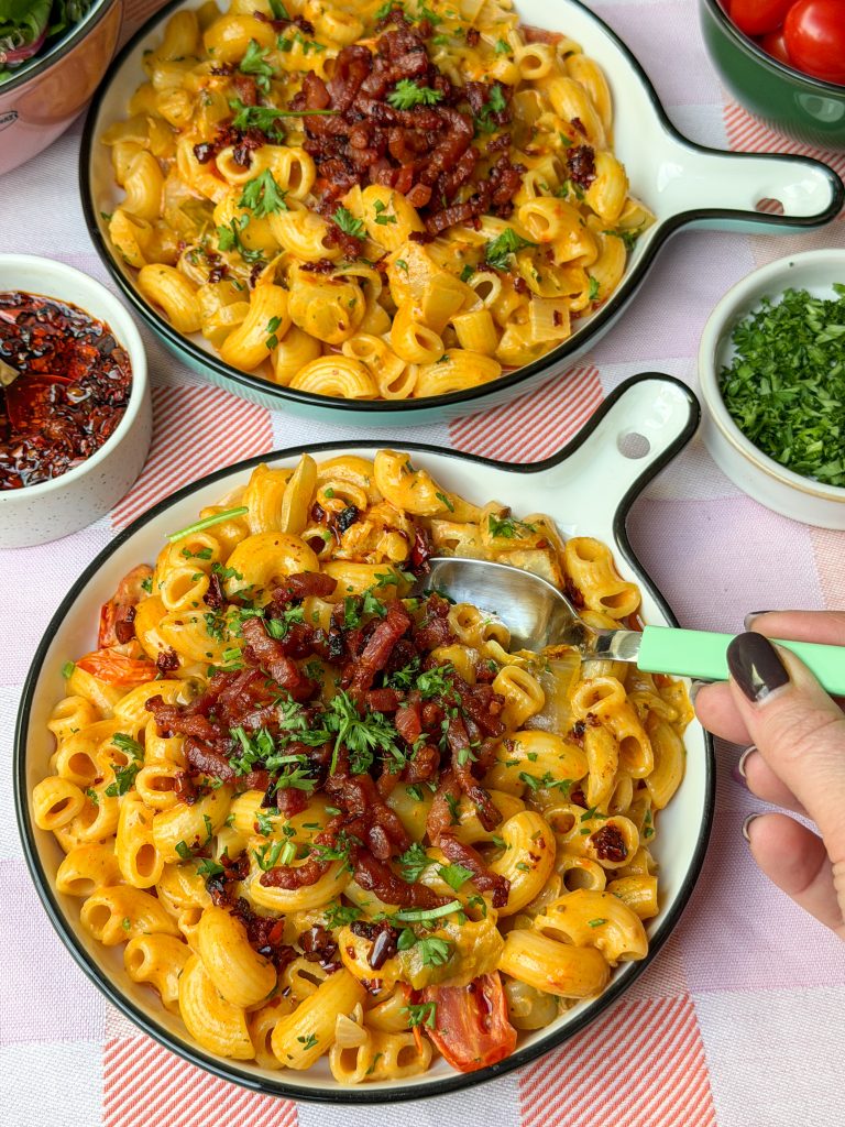 Romige pasta met witlof en spekjes geserveerd op rond rond met lepel