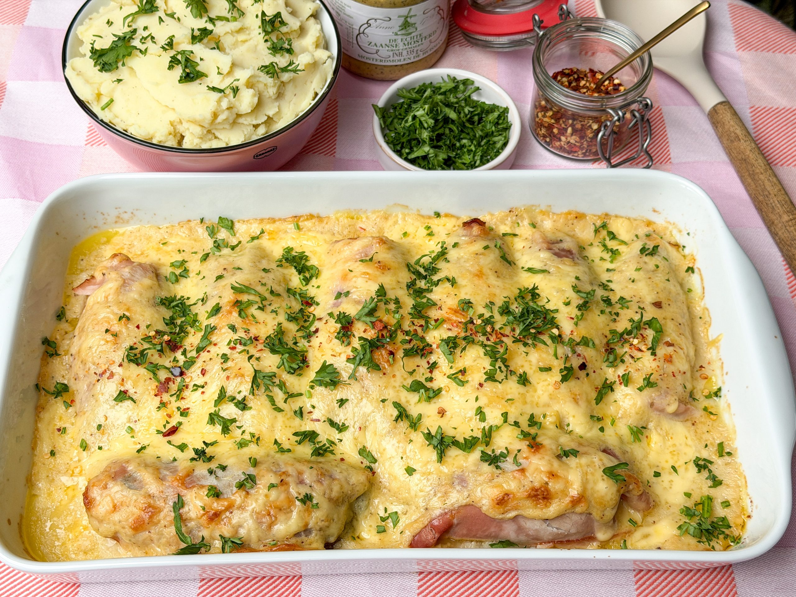 Goudbruine witlof met ham en kaas uit de oven geserveerd op tafel