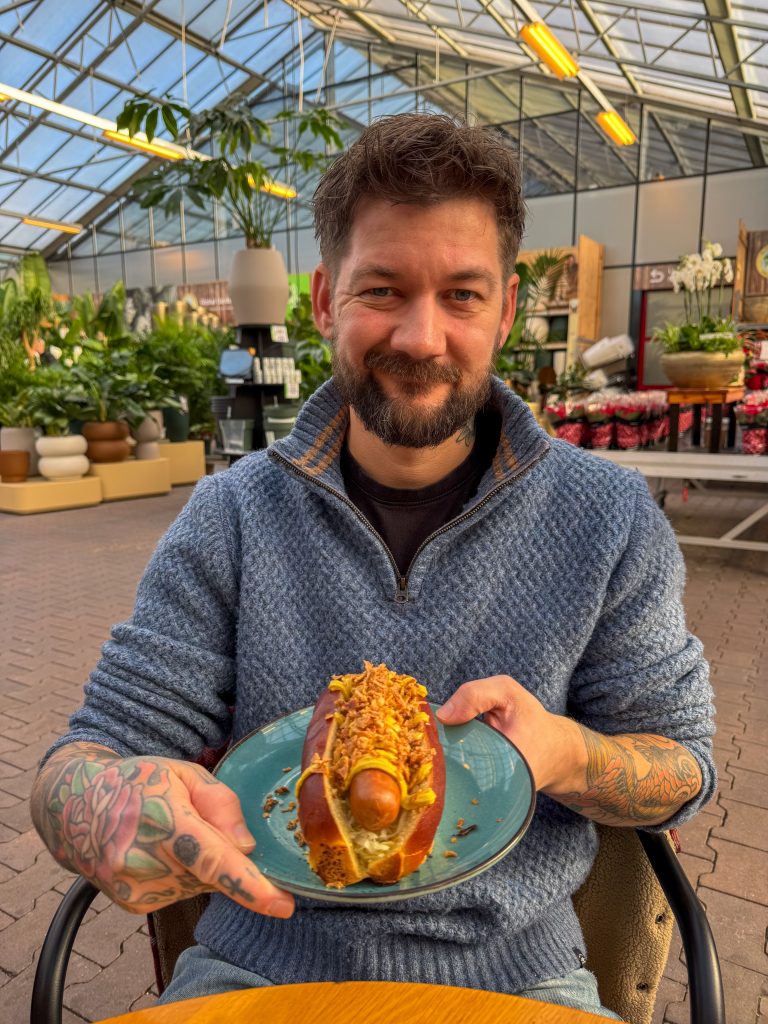 Jan Willem eet een hotdog in het tuincentrum