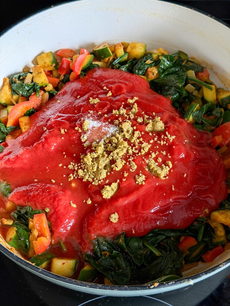 Tomatensaus en verkruimeld bouillonblokje toevoegen