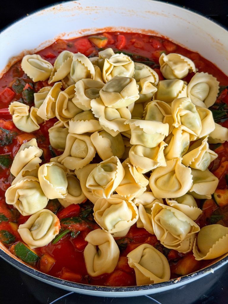 Ravioli toevoegen aan de tomatensaus met groenten