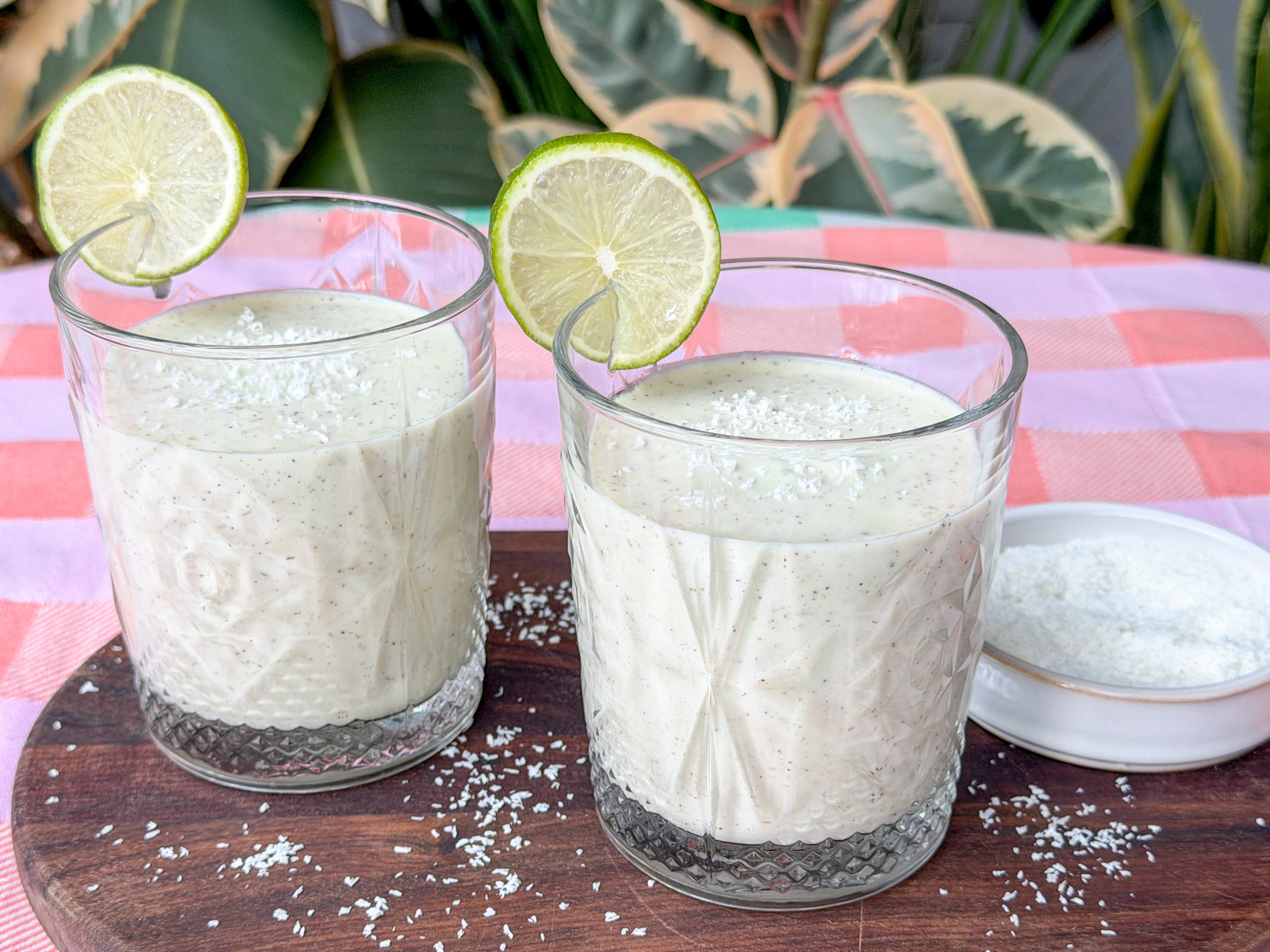 Smoothie met kiwi en banaan geserveerd in glazen met limoen