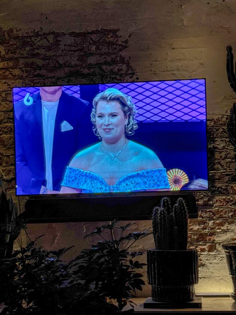 Tv-moment in de woonkamer met muziekprogramma en avondverlichting.