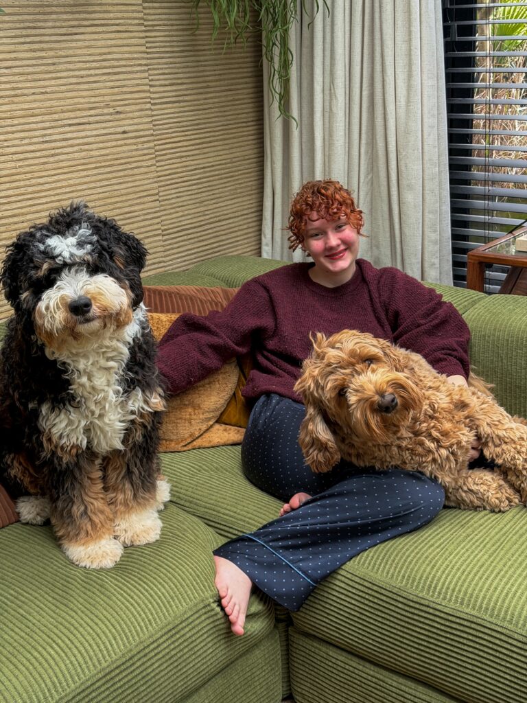 Amaranthe zit op de bank met Teun en Ledgie naast zich in de woonkamer.