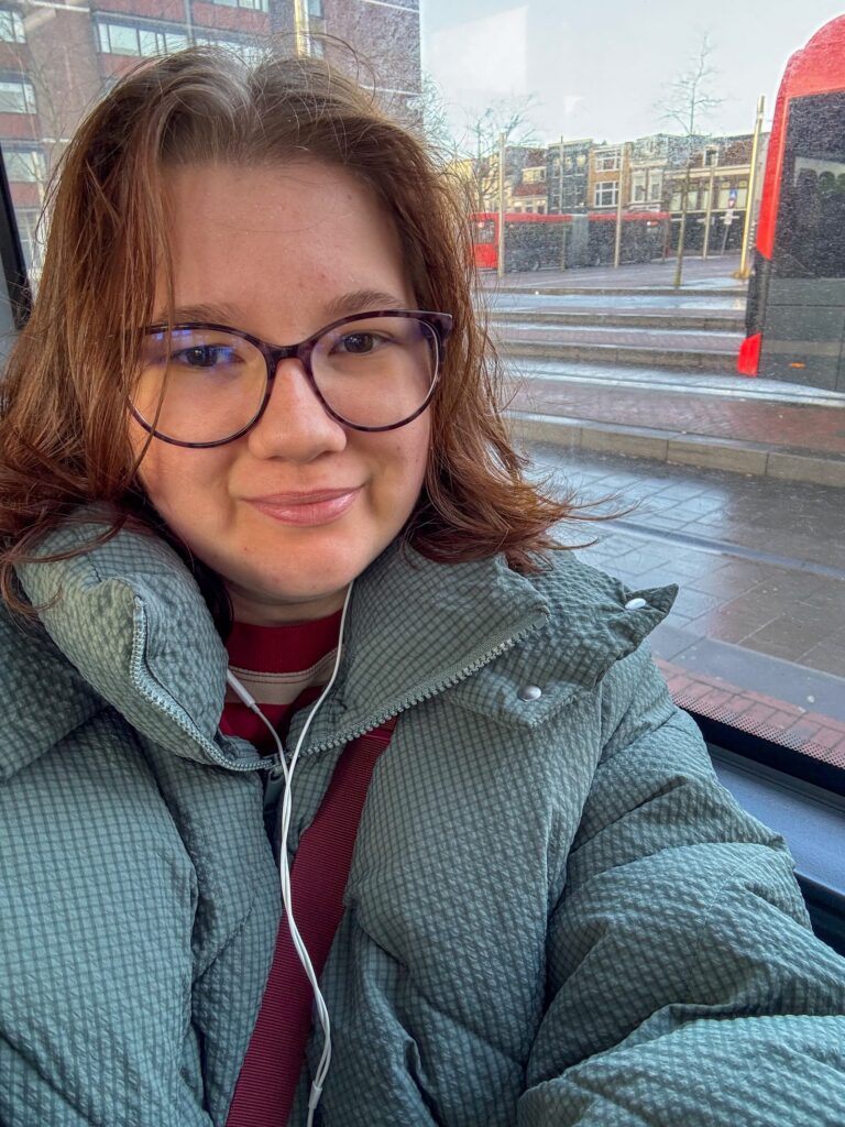 Beaudine in het openbaar vervoer met oortjes in.