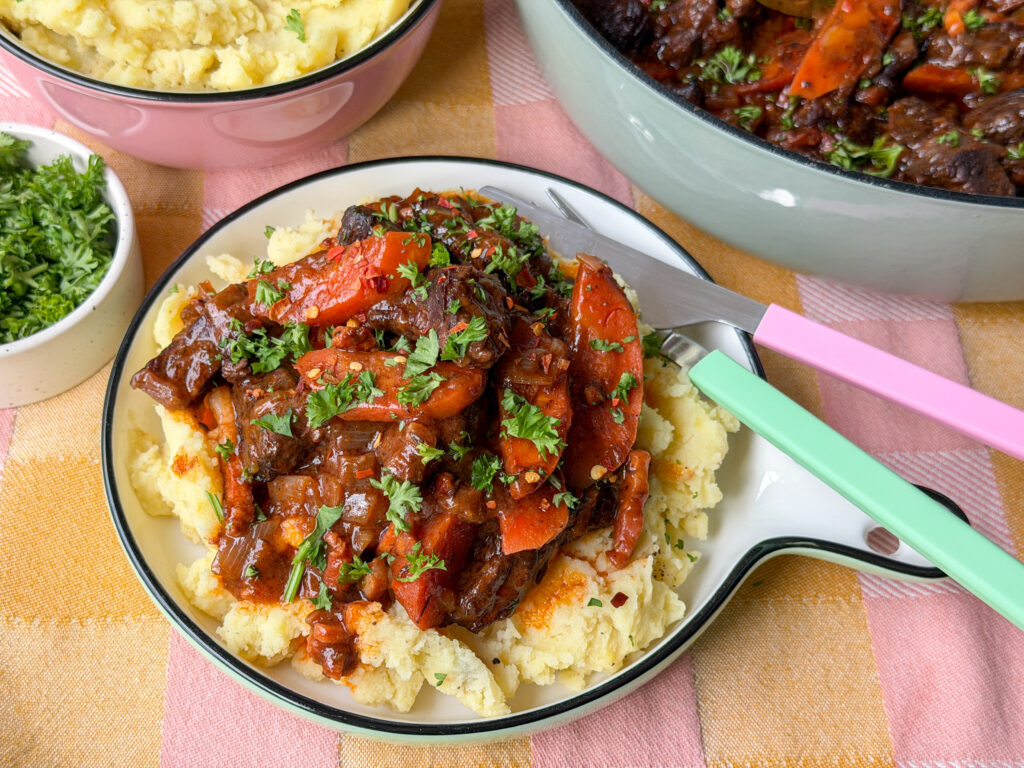 Boeuf bourguignon geserveerd met aardappelpuree op bord