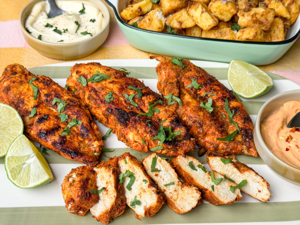 kipfilet op een schaal, geserveerd met krokante aardappels, limoen en sausjes