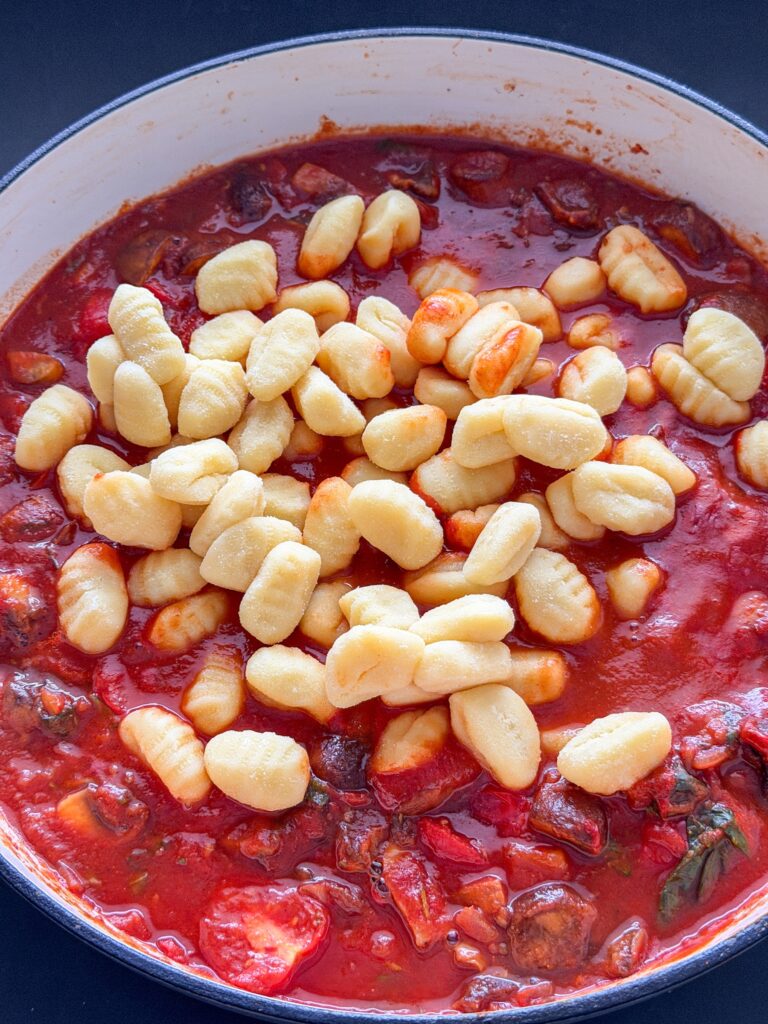 Gnocchi toevoegen aan de pittige tomatensaus