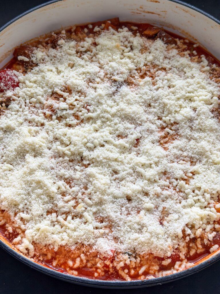 Kaas over de ovenschotel strooien voor het bakken