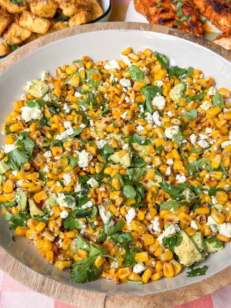 gebakken maissalade in schaal met feta, koriander en avocado